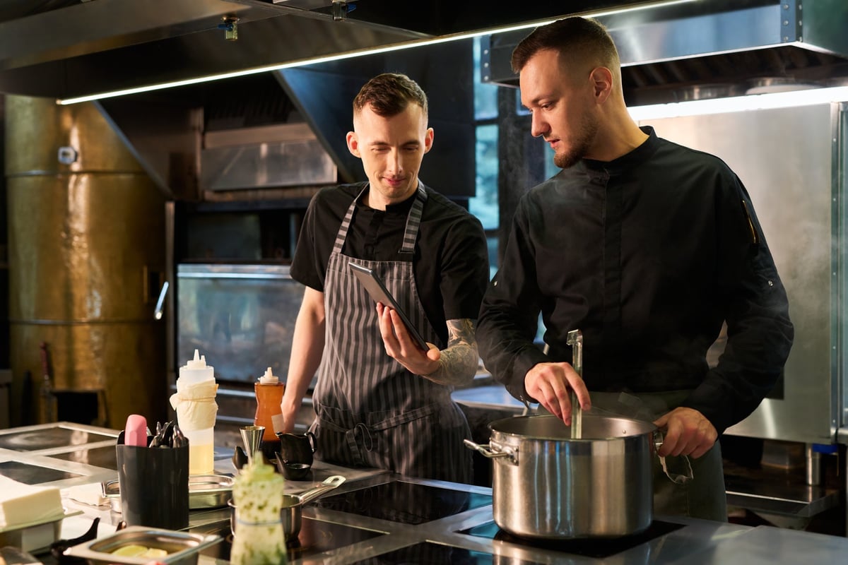 Two chefs working together in professional kitchen